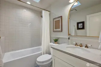 Second bathroom on upper level with skylight accessed from hallway.