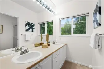 Primary 3/4 bathroom with dual sinks and a large walk-in closet.