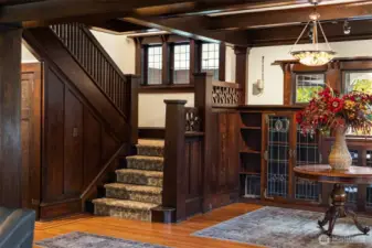 Rich woodwork and handcrafted details take center stage in the home’s iconic staircase hall. Leaded glass built-ins, original newel posts, and warm hardwoods reflect the craftsmanship and permanence of a bygone era.