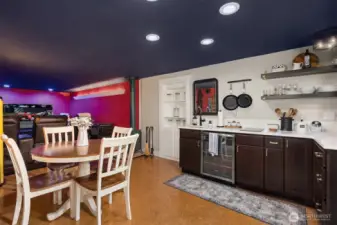 A stylish kitchenette anchors the lower level, ideal for entertaining. Open shelving, beverage fridge, and thoughtful prep space allow the speakeasy experience to flow seamlessly from tasting to dining to movie night.