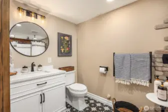 A beautifully finished lower-level bath features modern fixtures and thoughtful design, offering convenience and comfort for guests enjoying the entertainment spaces.
