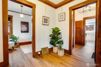 The formal entry showcases fresh paint, refinished hardwood floors, and stunning original millwork with classic crown molding.