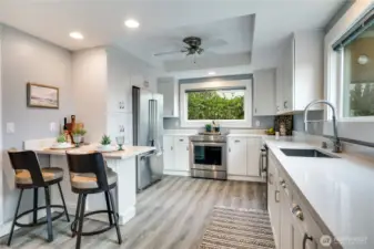 The updated kitchen shines with stainless steel appliances, sleek quartz countertops, a cozy breakfast bar, and a new luxury vinyl floor for easy maintenance.