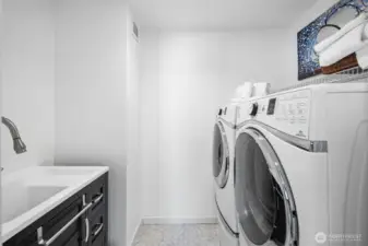 Separate laundry room with utility sink and storage