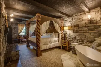Castle Suite king bed with wood-burning fireplace and soaking tub