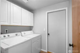Laundry and utility room. New cabinets add to the storage and use of this room.  Door leads to the 2 car garage with built in shop area.