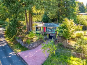 The aerial view of the front of the home shows the wide, double lots on the serene corner of Biscay and Sunset Beach Dr.  The gently sloped drive leads to the lovely water-side, no outlet neighborhood road with traffic.