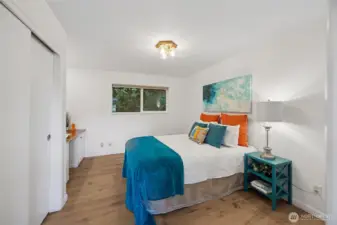 The second bedroom shows the generous space available for a queen size bed even with a built-in desk and large cedar-lined closet.