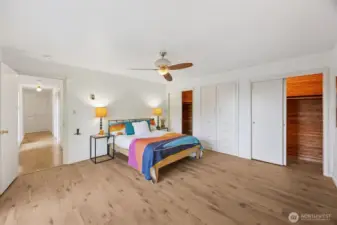 Looking through the primary bedrm., the long, view window hallway leads back to the other two bedrooms, the full bath, and the living/kitchen spaces. Note the double, cedar lined and lit closets and built-in wardrobe cabinet.