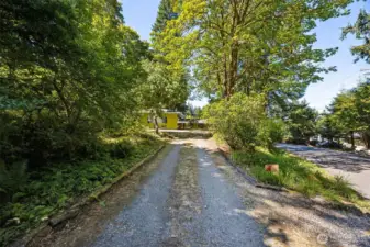 A long, fairly level driveway intersects the second lot and leads to the level shop parking area with turn around space, RV parking space, a large detached shop and the side entrance used as the primary access commonly.