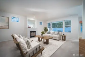Step into the gracious living room featuring a cozy gas fireplace and expansive picture windows that fill the space with natural light. Virtually Staged.