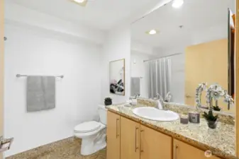 The guest bathroom is both stylish and functional, featuring a tub/shower combo perfect for kids, guests, or quick refreshes. Granite countertops add a touch of elegance and tie into the modern finishes throughout the condo.
