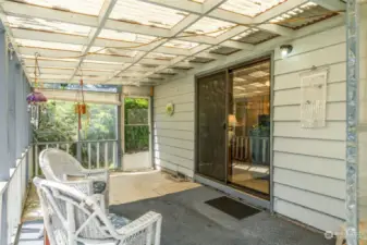 Covered entertaining patio with wrap around sidewalk to front on home.