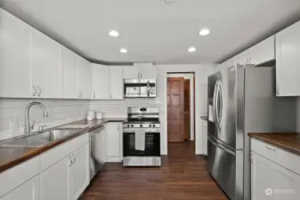 White shaker kitchen cabinets offer ample storage for all your essentials, while the expansive countertops provide plenty of space for effortless meal preparation.