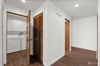 A separate laundry room includes a washer and dryer and wall mounted cabinetry for additional storage.