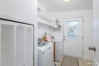 Mudroom/laundry w/shelving and additional cabinets.