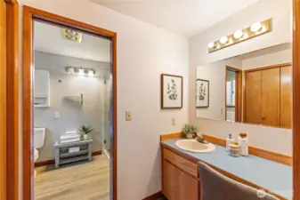 Primary en suite bath includes an extended vanity and dressing area with convenient storage.