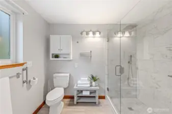 Updated en suite bath features a modern walk-in shower with tile surround and glass enclosure.