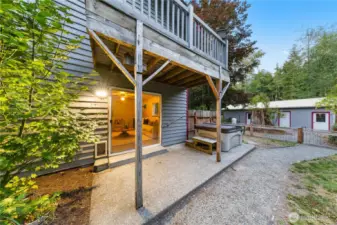Covered deck off the family room extends to a private hot tub area—ideal for year-round relaxation and entertaining.