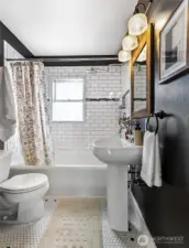 Main floor full bathroom with tile floors, pedestal sink, and built-in cabinetry (not pictured).