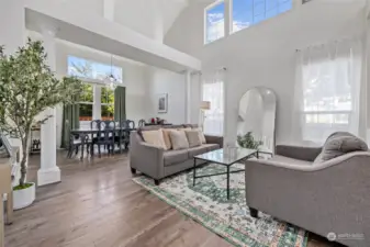 Enter into the light and bright living room and dining room boasting 2 story vaulted ceilings