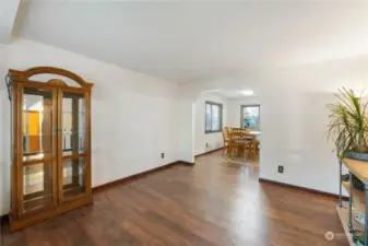 Last view of empty living room looking into dining room with new light interior paint with more wood trim and laminate wood flooring