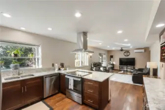 Beautifully updated open great room and kitchen with all new cabinets quartz counters ss appliances lots of counter top space 4 person bar recessed lighting and newer laminated hardwood flooring throughout