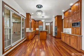 Chef's kitchen features a convenient eating space, large center island, double-door pantry and tons of cabinet storage.
