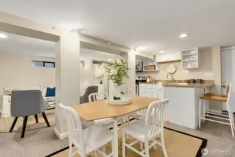 Enough room for a dining table. Kitchen has bar for stools. Door to outside is behind the stools.