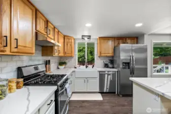 The kitchen comes equipped with all stainless steel appliances, featuring a gas stove.