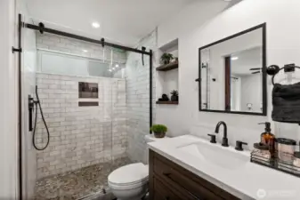 Large walk-in shower with a sleek, matte black-framed glass door.