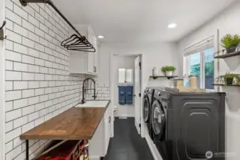 Discover a freshly updated laundry room designed for both style and function, featuring a subtle backsplash and sleek matte black features.