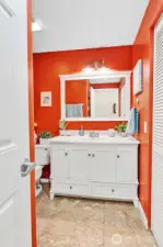 The bathroom features marble flooring and  beautifully updated vanity, mirror, and light  fixture. The laundry is to the right of this  photo.