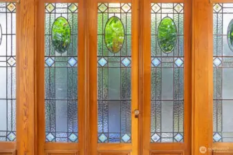 Sunroom off the kitchen is surrounded by reclaimed leaded glass doors from a French hotel.