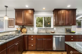 The kitchen features a full-height stone backsplash, stainless steel appliances and custom cabinets with crown moulding