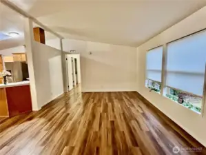 open floor plan living room leading to dining room, kitchen and primary bedroom