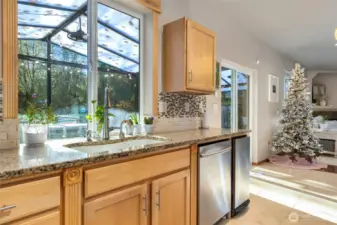 Updated kitchen with solid surface stone counters, tile backsplash, undercabinet lighting, gas range. Serene views from kitchen, dining, living.