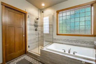 Primary shower & soaking tub.  Door leads to walk-in closet.
