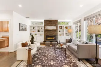 Cozy secondary living area with surround sound, gas and stone fireplace, custom built in shelving, large picture windows overlooking backyard patio.