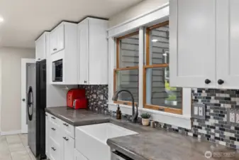 Gourmet kitchen featuring stainless farm-house sink and tile backsplash.