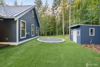An inground trampoline and kids cedar lined play house with electricity.