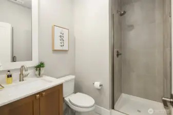 Tile floors and shower with glass door w/white quartz vanity. 1 step from the main level bed or den.