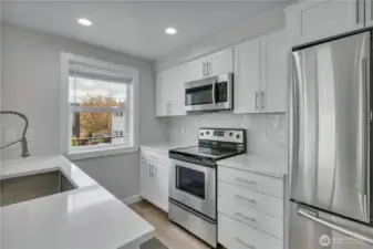 Newly updated kitchen with quartz counters, soft close cabinetry, SS appliances, large one-bowl sink.