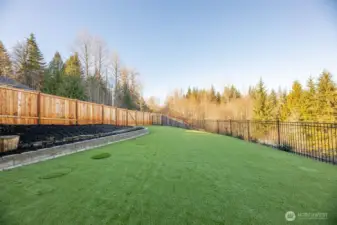 New fully fenced upper back yard area with fake grass for easy upkeep.