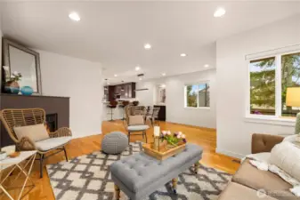 Open floor plan on the main level with gas fireplace, dining area, and kitchen bar seating.