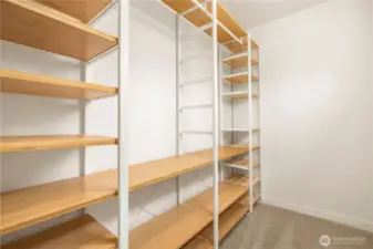Walk in closet has custom storage built in.