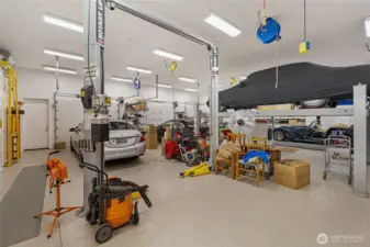 Expansive professional-grade workshop and garage with vehicle lift, high ceilings, and abundant workspace—ideal for collectors, hobbyists, or creative pursuits within this exceptional San Juan Island estate compound.
