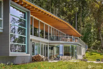 Striking architectural design meets the natural beauty of the San Juan Islands, with expansive walls of glass and warm wood beams framing panoramic water views from nearly every room.