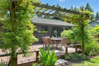 The large back deck with mature landscaping.
