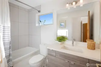 Attached full bathroom with modern finishes and ample counter space.